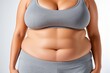 © Michael - Frau mit sportlicher Kleidung und Plus-Size-Figur zeigt selbstbewusst ihre Körpermitte vor neutralem Hintergrund