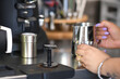 © Antonia - Barista Preparing Espresso Shot Pouring into a Small Glass With Milk Steaming Pitcher Ready for Coffee Making