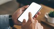 © Djemari - Close-up of a person's hands holding and interacting with a smartphone.
