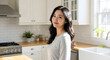 © Daniel Park - Portrait of a happy young Asian woman smiling in her beautiful, modern sunlit kitchen, enjoying a healthy lifestyle at home.