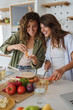 © Dorde - Two Women Friends Cooking Together In Modern Kitchen With Fresh Vegetables And Natural Light