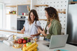 © Dorde - Young Women Friends Cooking Together in a Modern Bright Kitchen, Surrounded by Fresh Ingredients