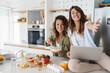 © Dorde - Happy Young Women Friends Cooking and Smiling in a Bright Modern Kitchen
