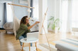 © Dorde - Smiling Woman Creating Artwork in Bright Stylish Home with Minimalist Interior and Natural Light