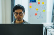 © weedezign - Asian man  prompt engineer develop coding app with software data sitting in front of computer monitor at office