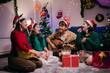 © Parichat - Friends celebrating Christmas enjoying music and gifts at home