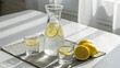 © gleb - Glass carafe and drinking glasses filled with lemon water on bright table with whole lemons nearby, perfect for detox diet visuals, wellness blogs and healthy lifestyle concepts