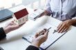 © Ngampol - Estate agent sending house model to client after signing agreement contract real estate with approved mortgage application form, concerning mortgage loan offer for and house insurance
