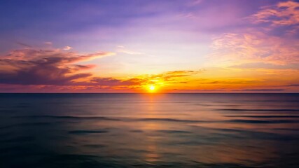 Wall Mural - Sunrise over the tranquil sea with a vibrant orange and red sky reflecting on the still water