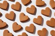 © Takalar - Heart-shaped cookies arranged in a grid pattern on a white background.  Each cookie is a light brown hue, with a slightly textured surface.  Shadows are cast beneath each cookie, adding depth