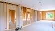 © Tarno - A spacious interior view of a house under construction, showcasing the wooden framing and drywall installation.