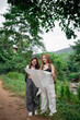 © WMSTUDIO - Two Friends Exploring Nature Together While Consulting a Map in Lush Green Environment on a Cloudy Day