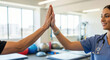 © Aurora Aesthetics - Physical therapist nurse and a patient giving a high-five to celebrate a successful rehabilitation exercise