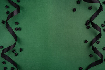 Wall Mural - chic black baubles, stars, and golden ribbon frame a green background, creating a bold and modern ho