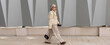 © Ivan Traimak - Elegant older woman walks confidently along a stylish urban pathway beside modern architectural design