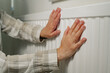 © Inga - Woman warming up hands over heater. Increasing bills expenses. Cold season. Rising utility costs