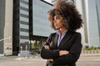© Vane Nunes - Afro latina business woman standing outside with office buildings on background - Corporate female leadership