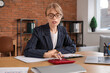 © Pixel-Shot - Young female accountant in eyeglasses doing paper work at workplace with laptop and calculator in office