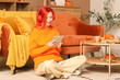 © Pixel-Shot - Beautiful young happy woman in headphones with autumn decor and tablet sitting on floor at home