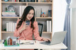 © ArLawKa - Real estate agent sitting in office workplace, concept of buying and loan in home title working, laptop computer while other hand holding model house.