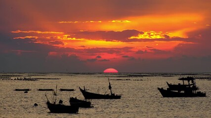 Wall Mural - Dramatic sunset at the ocean with many boats on foreground.