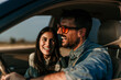 © La Famiglia - Happy couple laughing and enjoying road trip in car