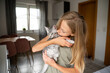 © ADDICTIVE STOCK - Young girl embracing cute grey kitten in cozy home