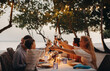 © Jacob Lund - Family enjoying dinner at a beachside vacation with a toast