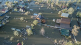 Aerial drone footage showing severe flooding with submerged houses and roads. Wide overhead view of a disaster zone after heavy rainfall, showcasing water damage, extreme weather, and climate-related 