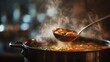 © fivan - Abstract crop of ladle full of autumn soup over steaming pot, soft bokeh and muted kitchen backdrop