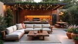 Modern backyard patio with plush sectional sofa, reclaimed wood coffee table, outdoor kitchen. Rich plants surrounds space, complemented by string lights for ambient evening dining. Features