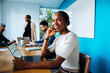 © (JLco) Julia Amaral - Smiling professional woman sitting at a table during an office meeting