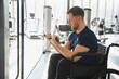 © Serhii - Man with disability lifting weights in wheelchair at gym for rehabilitation