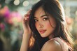 © MOON - Beautiful Asian woman with long silky hair and flawless skin wearing sleeveless dress, natural soft makeup, gently touching her hair in floral blurred portrait background
