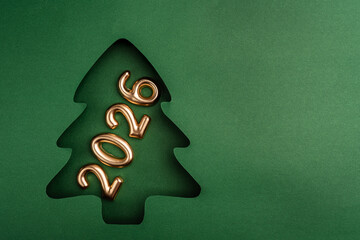 Wall Mural - gold number candles forming 2026 are placed inside a green paper christmas tree cutout, celebrating 