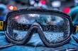 © whitestorm - Close-up of safety goggles covered in water droplets reflecting bokeh lights.