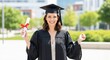 © Nazlykhan - Young caucasian female graduate celebrating success outdoors in a gown and cap
