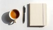 © Yassine - A simple and aesthetic flat lay featuring a cup of tea a pen and a notebook for creative ideas and journaling inspiration