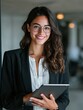 © Johannes - portrait of young hispanic professional business woman standing in office happy female company executive smiling businesswoman entrepreneur corporate leader manager looking at camera using tablet