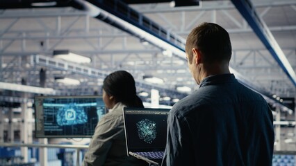 Data center software developer using AI LLM chatbot suggestions to adjust rigs system settings. Server hub IT professional using large language model on laptop to manage infrastructure, camera B