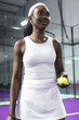 © Wavebreak Media - African american female tennis player in white holding yellow ball on purple court at venue