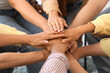 © Pixel-Shot - Young people putting hands together at group therapy session, closeup