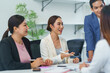 © Crystal - Asian businesspeople discussing during a meeting in a modern office, collaborating and sharing ideas