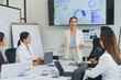 © Crystal - Businesswoman presenting company performance data to colleagues during a meeting in a modern office