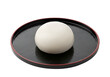 © Pain - Round, white, steamed bun sits on a black lacquered tray, showcasing simple elegance.