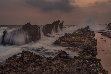 Wall Mural - Dramatic seascape with jagged rocks and waves.