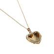 © andyaziz6 - Close-up of an elegant gold heart-shaped locket pendant on a delicate chain necklace isolated