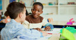 © BuyOutFelix03/peopleimages.com - Learning, students and friends in classroom for knowledge, test and writing exam or study. Kids, talking and team in lesson for education or children for conversation and talk together at school
