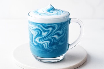 Wall Mural - blue and white swirled latte in a transparent glass mug on a light surface with soft white backgroun