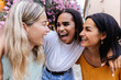 © Xavier Lorenzo - Three young diverse women laughing together outdoors. Female friendship and summer vacation lifestyle concept
